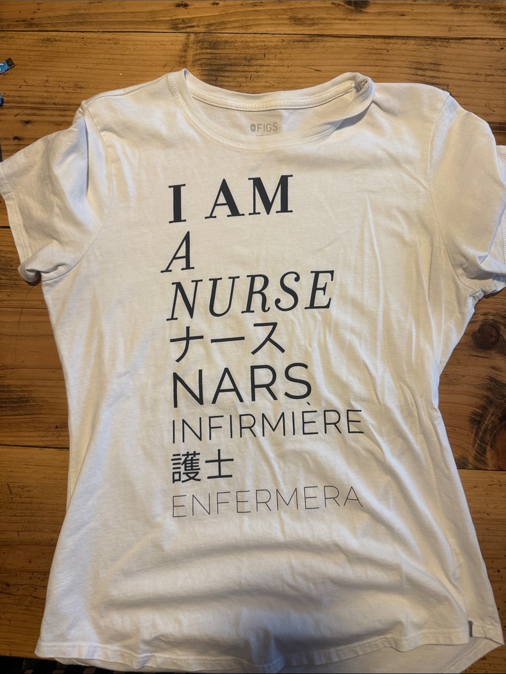Figs White Tee with Black Multilingual 'I AM A NURSE' Graphic